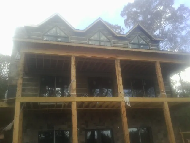 Dormers and porch framing on a large log home under construction — Roof Coating work by our crew in Chehalis